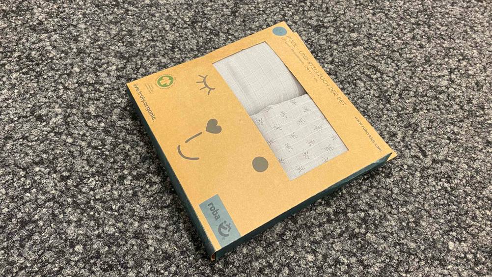 Pucktuch im Test: Pucktuch aus Baumwolle befindet sich verpackt auf dem Boden.