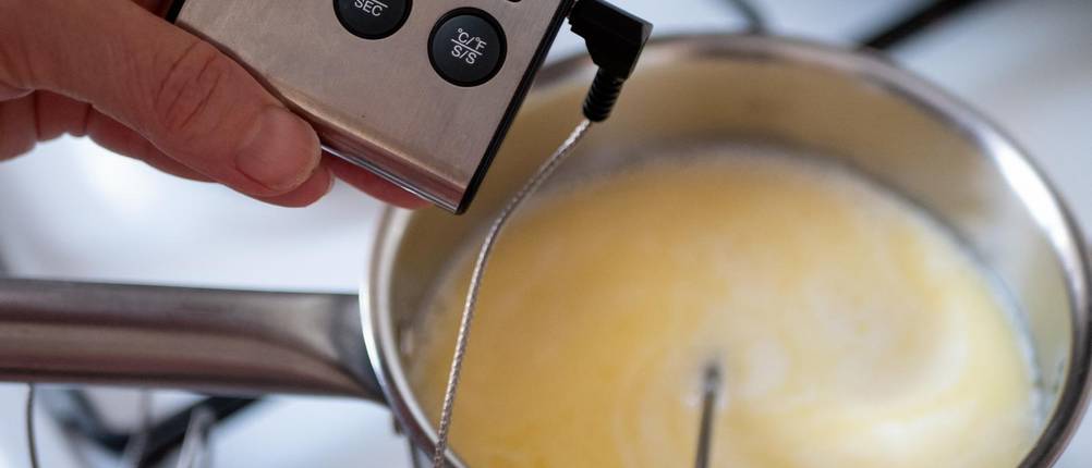 Puddingform-Test: Pudding wird im Topf gekocht; über Stabthermometer wird die Temperatur kontrolliert
