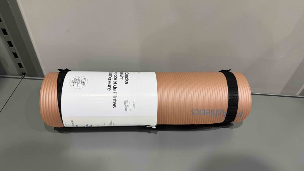 Eine zusammengerollte Yogamatte XL liegt getestet auf einer grauen Fläche.