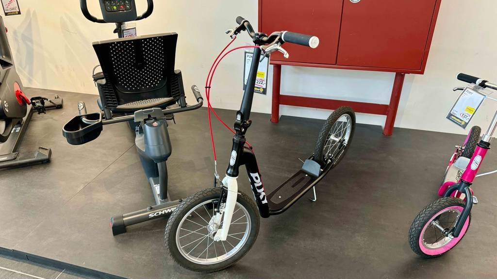 Ein Roller mit Luftreifen steht zum Testen zwischen anderen Geräten.