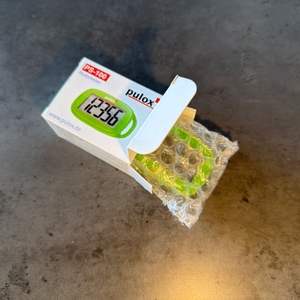 Der Pulox PS-100 wurde halb aus dem Karton gezogen