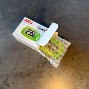 Der Pulox PS-100 wurde halb aus dem Karton gezogen