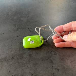 Eine Hand befestigt die Handschlaufe am Pulox PS-100