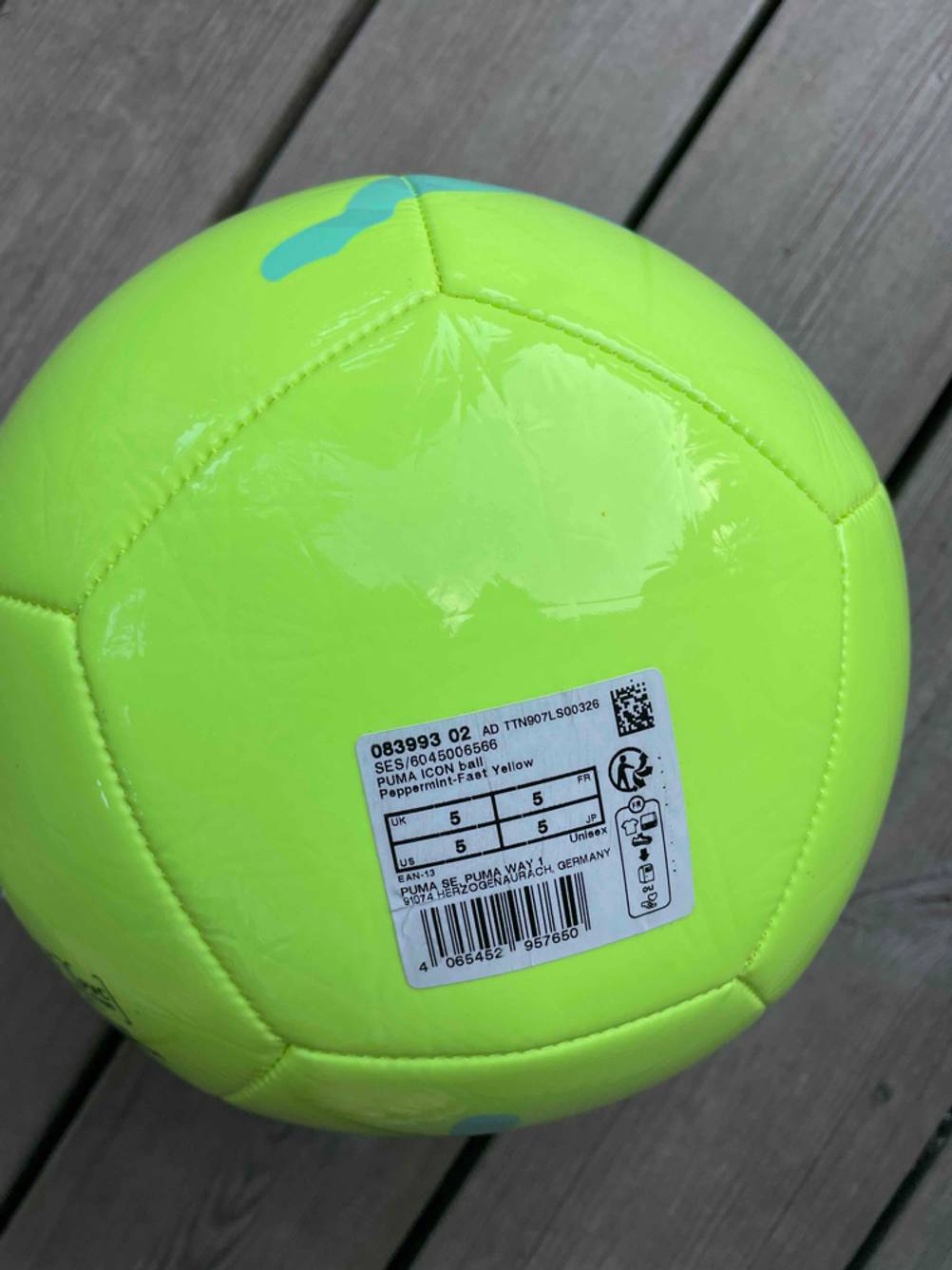 Auf einem gelben getesteten Fussball klebt das Produktetikett.