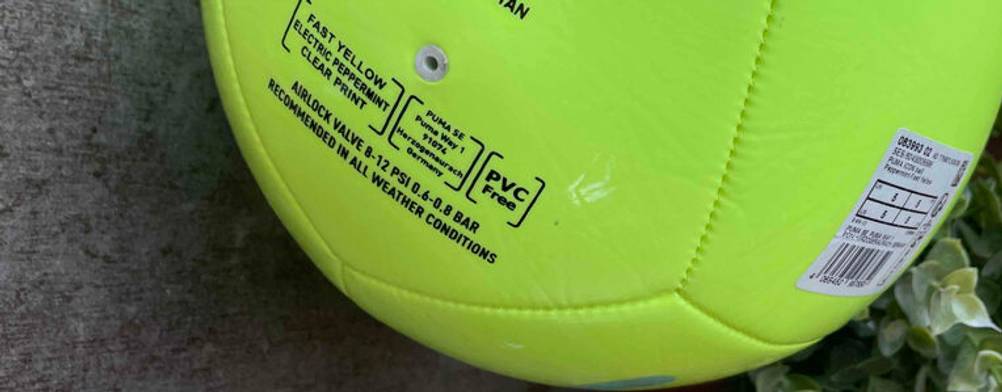 Fußball-Test: ein leuchtend gelber Fußball, der kein PVC enthält, liegt auf einem grauen Boden.