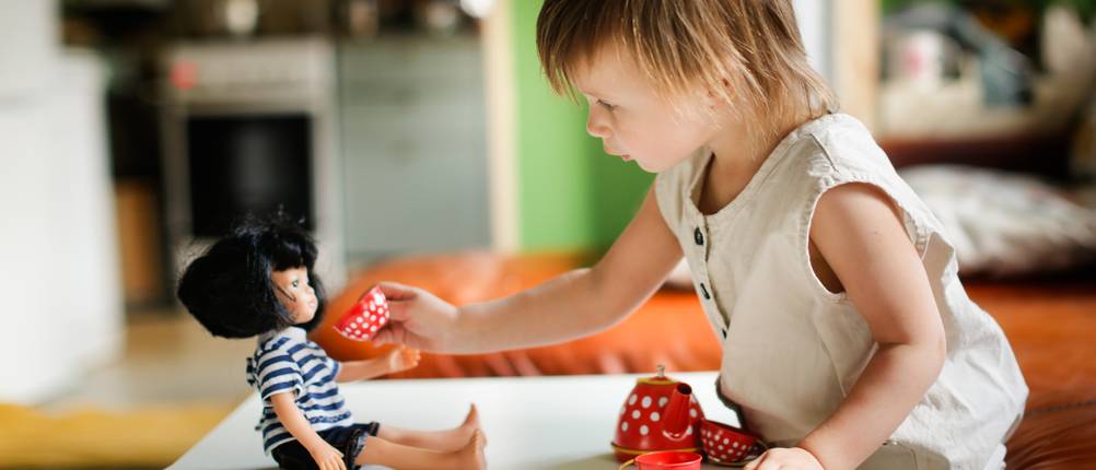 Puppengeschirr im Test: Ein Mädchen hält einer Puppe eine Tasse hin