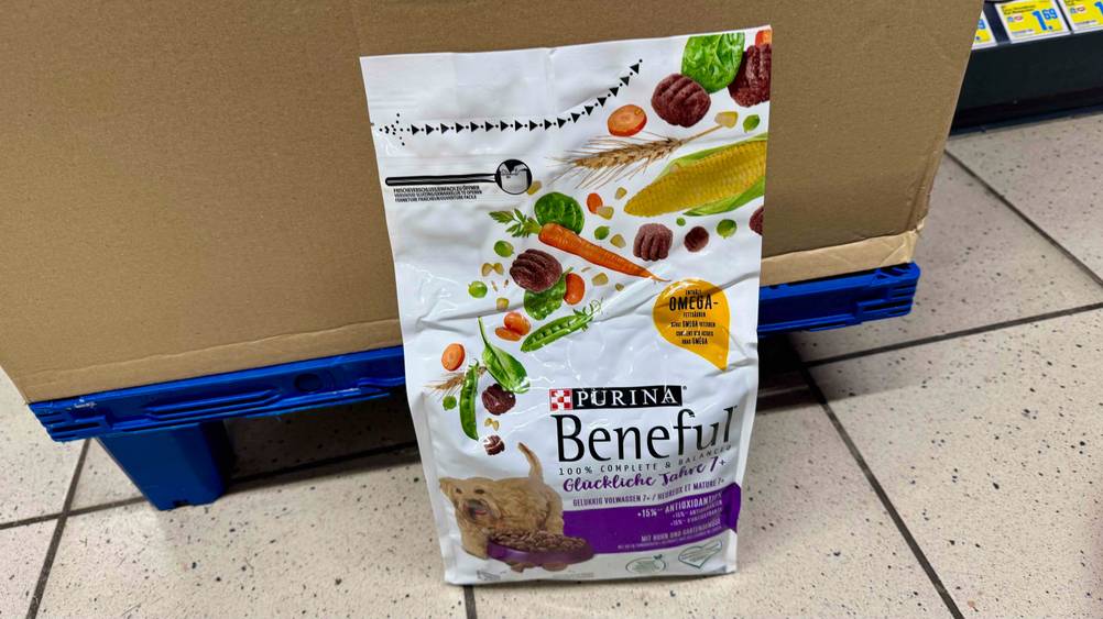 Eine Packung des getesteten Purina-Hundefutters vor einem Karton auf dem Boden stehend.