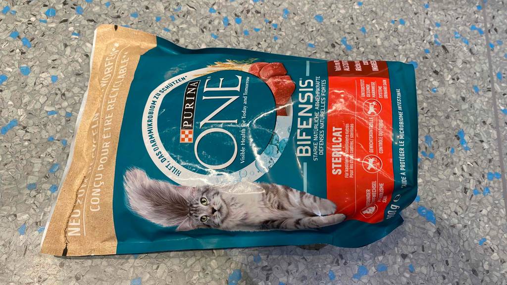 Im Test: Eine Packung Purina Katzenfutter One liegt auf einem Boden.
