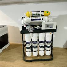 Die Purway-Osmoseanlage steht auf einer Arbeitsplatte. Sichtbar sind Filter, Manometer, Steuerbox und der gelbe Mineralfilter.