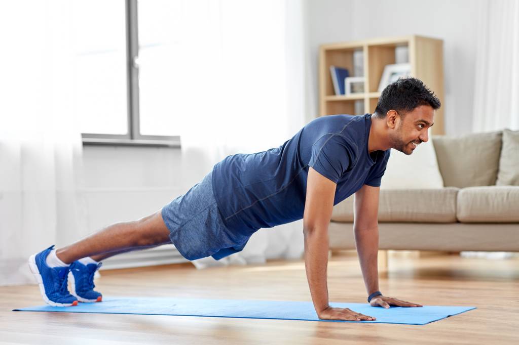 Push-up-Board-Test: Ein Mann man Fitnessübungen auf einer Fitnessmatte. 