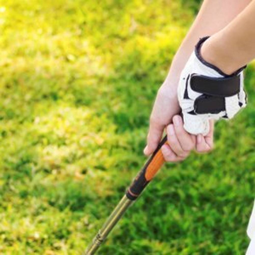 Golfer, der Golfhandschuhe trägt und einen Golfschläger greift