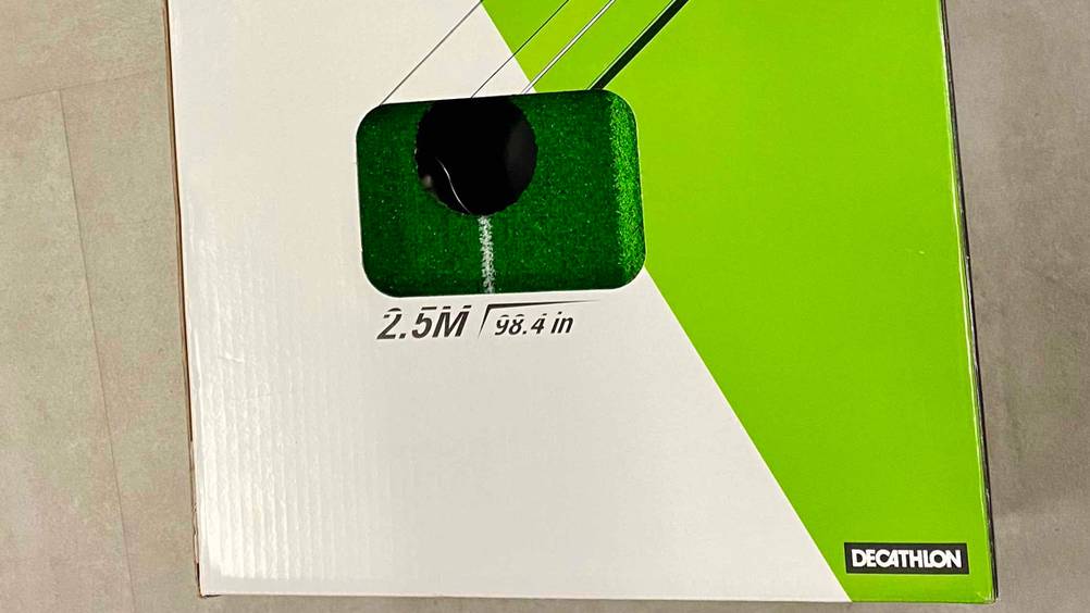 Nahaufnahme der verpackten Putting-Matte mit Sichtfenster und Logo.