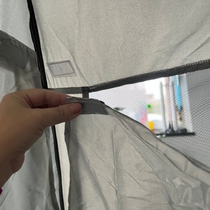 Eine Hand löst den Klettverschluss am Fenster der Qeedo Quick Palm Z3513