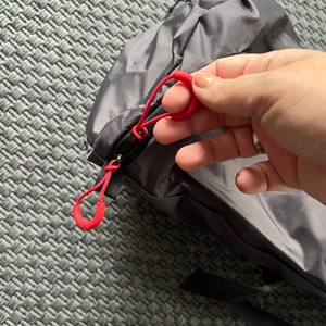 Eine Hand hält einen Reißverschluss an der Transporttasche der Qeedo Quick Palm Z3513 fest