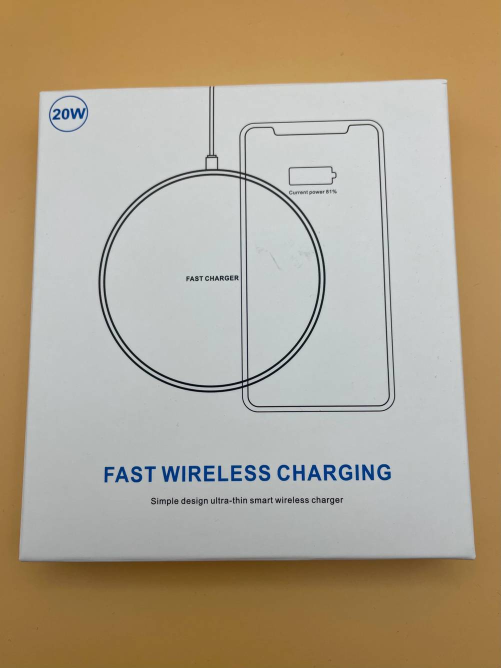 Ein verpacktes Qi-Ladegerät im Test auf einer gelben Fläche liegend.