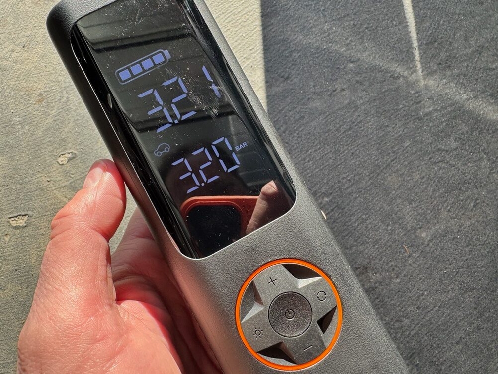 Eine Hand hält die Qicycle Qjcqbp1 fest, während das Display 3,2 bar anzeigt.