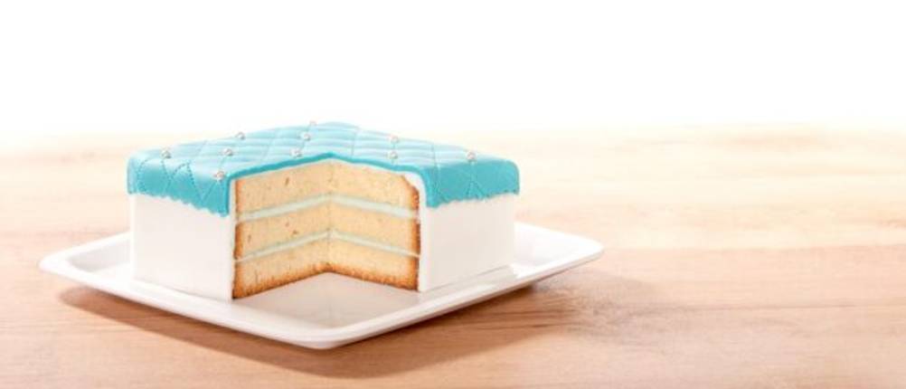 Quadratische Springform Test: kleiner quadratischer Kuchen auf einem weißen, quadratischen Teller, ein Stück fehlt