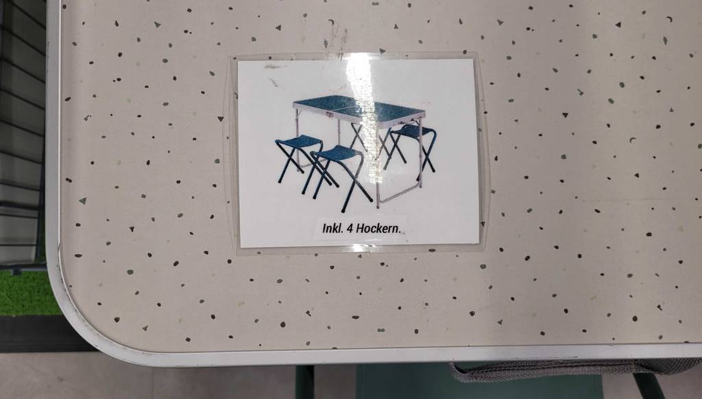 Nahaufnahme des Aufklebers eines Campingtisch-Sets im Test auf einer weißen Tischplatte.