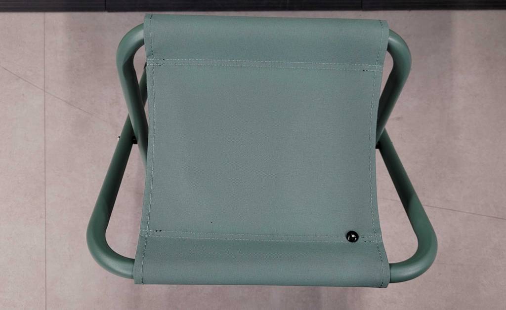 Campingtisch-Set im Test: Ansicht von oben auf einen Klapphocker aus grünem Leichtmetall inklusive grüner Stoff-Sitzfläche.