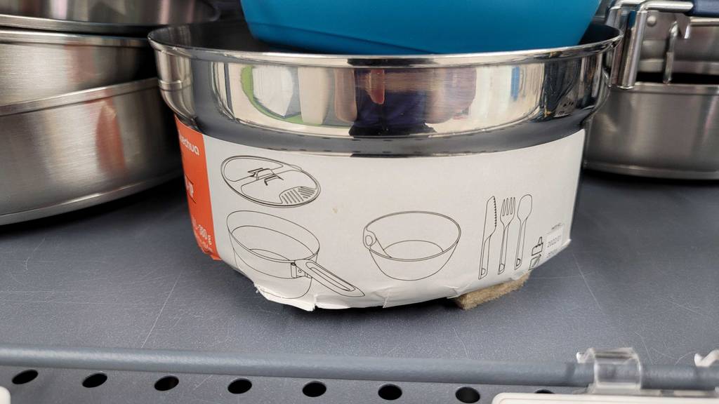 Auf dem Topf eines getesteten Campinggeschirrs ist ein Aufkleber mit bebilderten Informationen zum Inhalt.