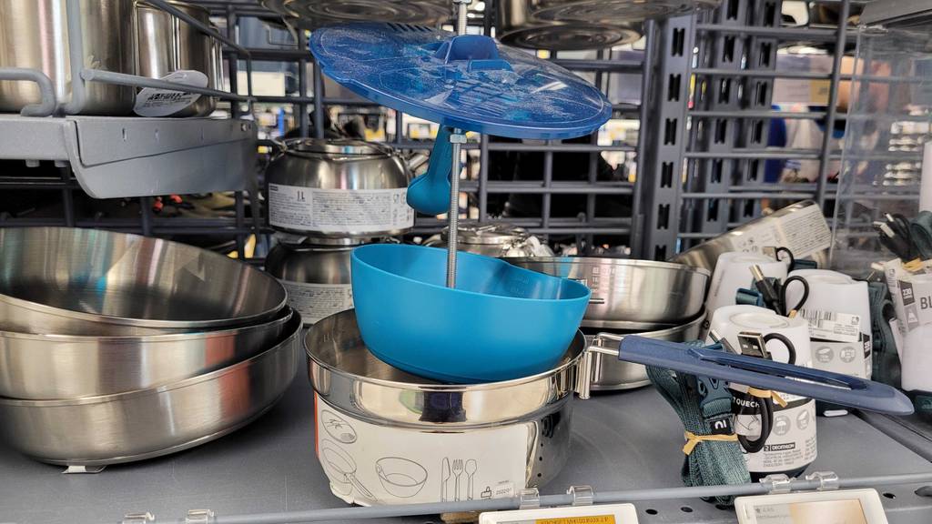 Campinggeschirr im Test: Ein Set mit Topf, Schüssel und Besteck steht in einem Regal mit einigen anderen Produkten.