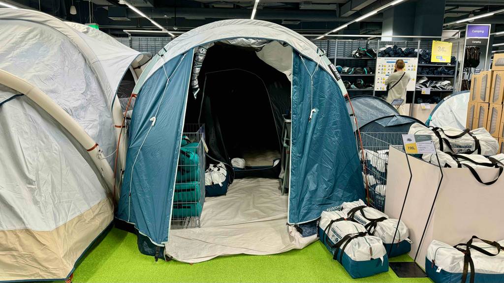 Familienzelte im Test: Ansicht auf den Eingangsbereich eines aufgebauten Modells der Marke Quechua, das sich in einem Ausstellungsbereich befindet.