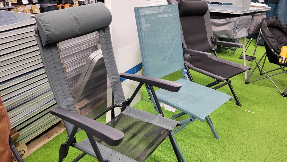 Ein Campingstuhl im Test neben anderen auf einem Kunstrasen.