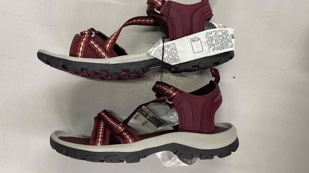 Im Test: Trekkingsandalen für Damen von Qechua liegen übereinander seitlich auf weißer Fläche.