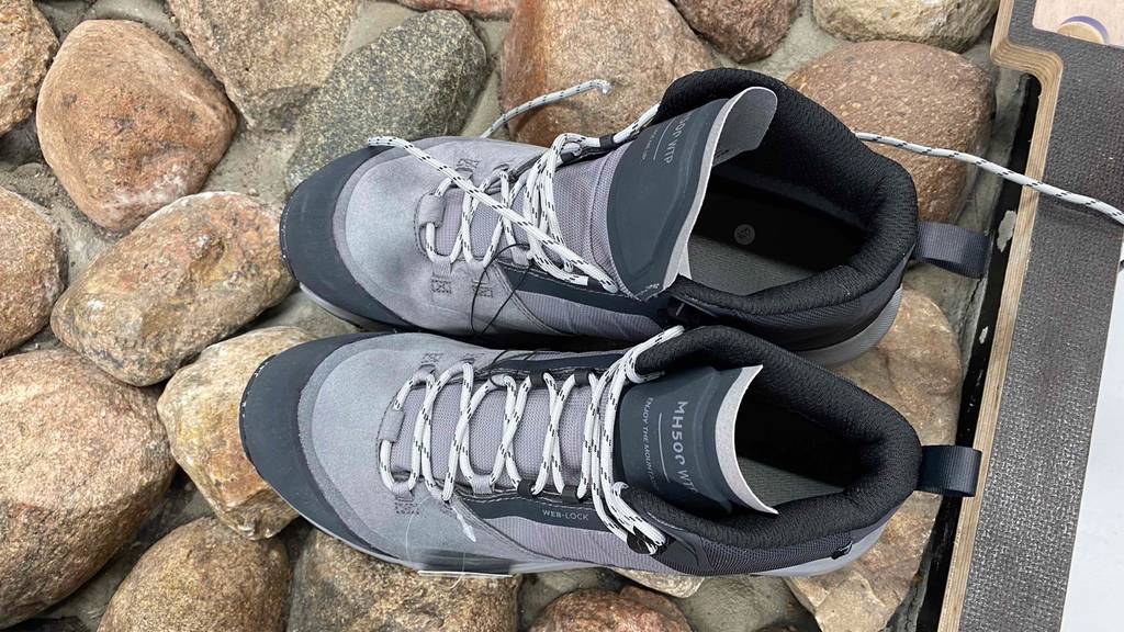 Getestet: ein Paar Bergschuhe für Herren steht auf großen Steinen.