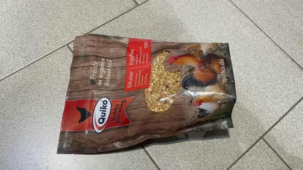 Quiko-Hühnerfutter-Test: Eine wiederverschließbare 500-g-Packung mit Hühnerfutter liegt auf einem hellgrauen Boden.