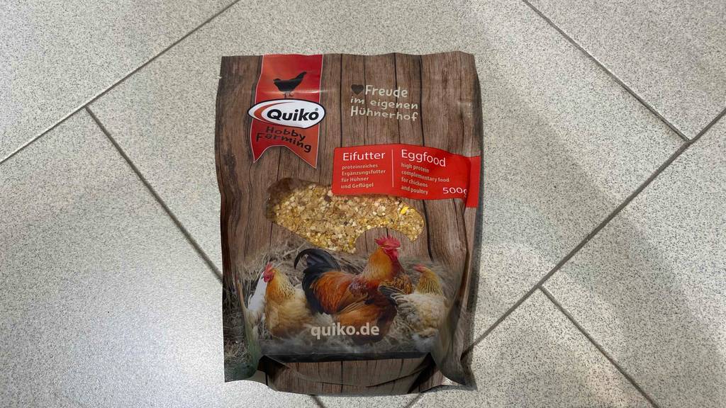 Quiko-Hühnerfutter im Test: Die 500-g-Verpackung mit Hühnerfutter liegt auf einem hellgrauen Fliesenboden.