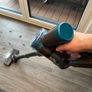 Der Quilted Northern Akku Staubsauger beim Saugen über Fliesenboden