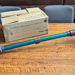 Der Quilted Northern Akku Staubsauger liegt vor seiner Verpackung auf einem Tisch