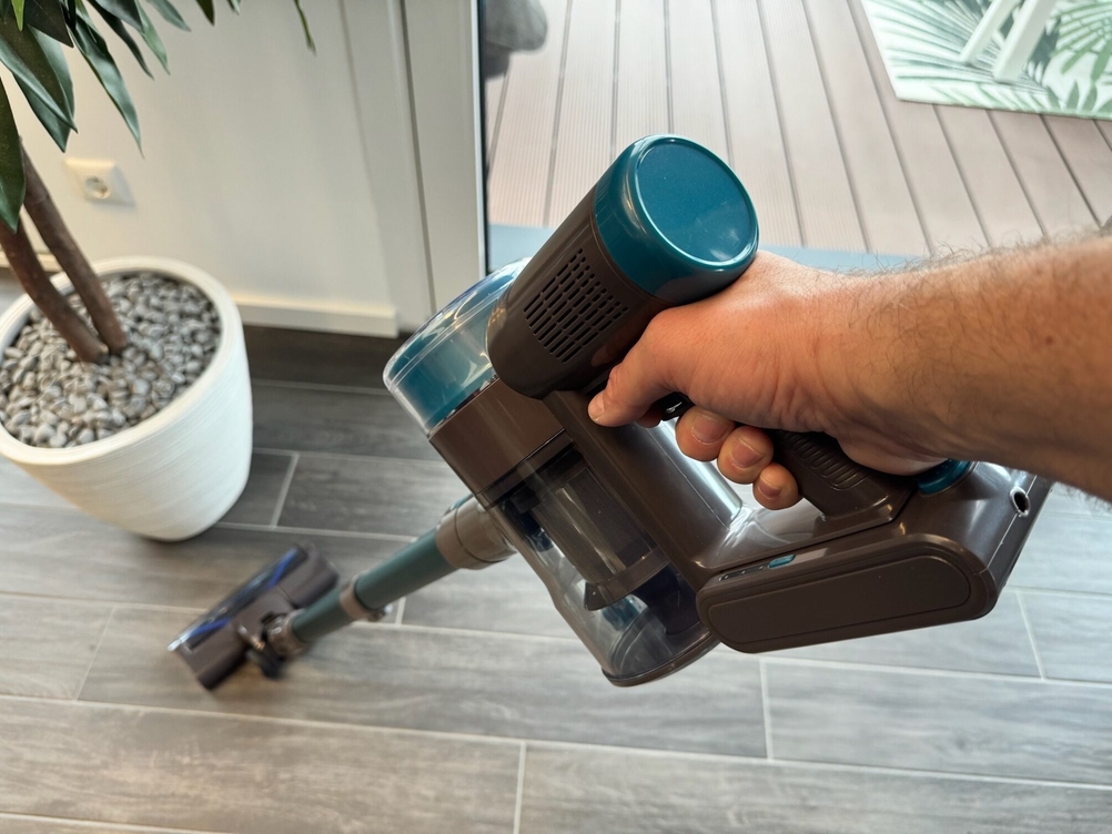 Der Quilted Northern Akku Staubsauger wird von einer Hand in Saugposition gehalten