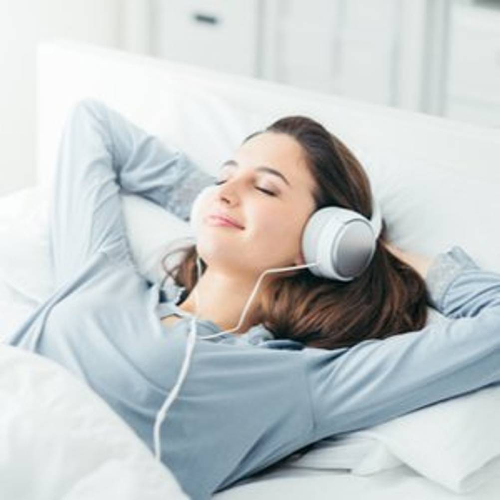 frau hoert ueber kopfhoerer musik