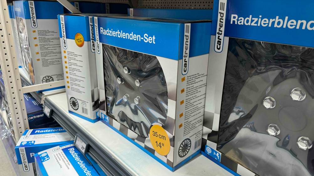 Mehrere getestete Radkappen in der Originalverpackung in einem Regal.