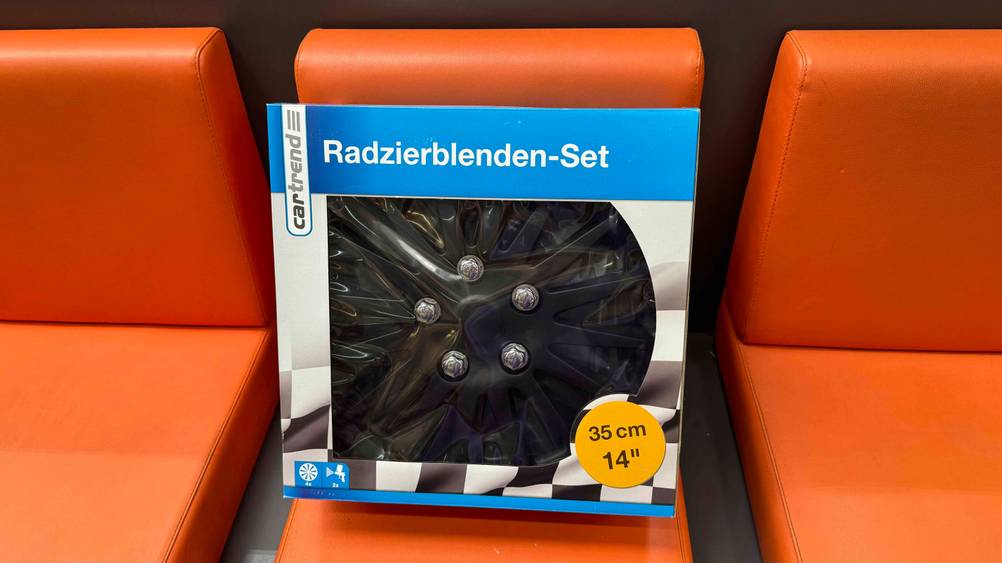 Radkappen getestet: Ein originalverpacktes Set auf einem roten Polster.