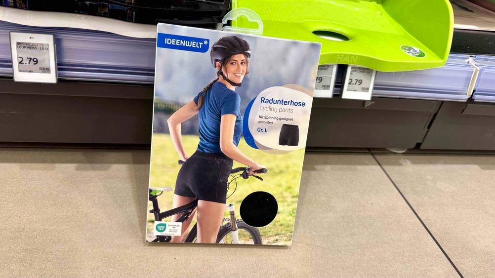 Vor einem Regal auf dem Boden steht eine Packung der getesteten Radunterhose Damen.