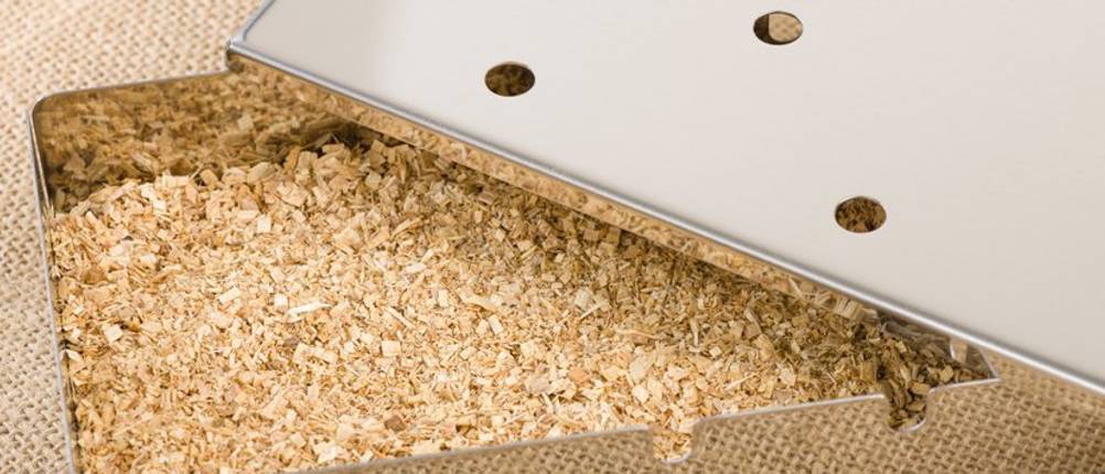Räucherbox-Test: Edelstahl-Räucherbox mit sehr feinen, hellen Holzchips befüllt.
