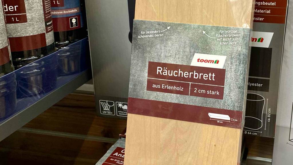 Nahaufnahme des Labels eines verpackten Räucherbretts mit Logo und Informationen.