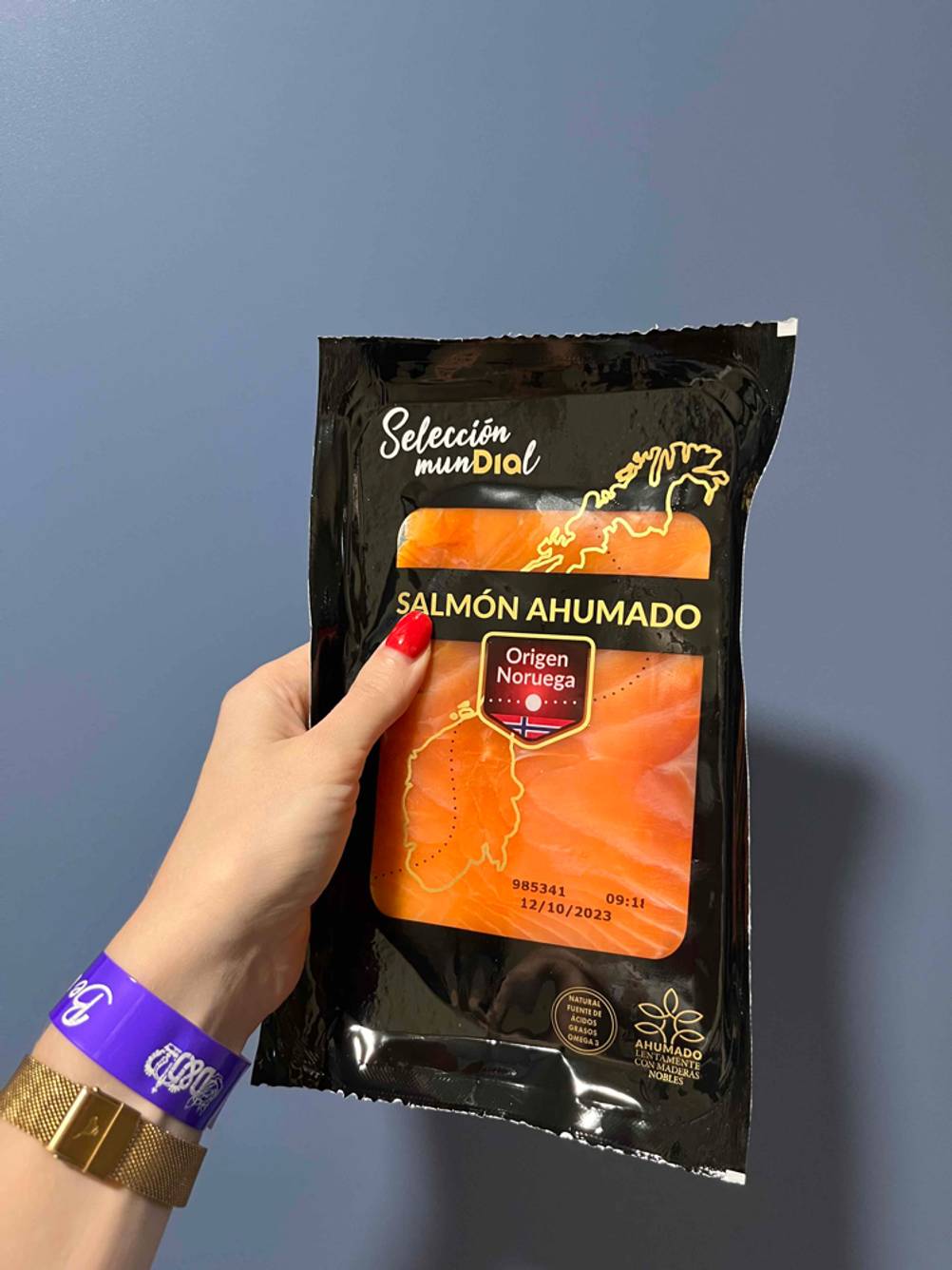 In der Hand befindet sich eine Packung getesteter Räucherlachs.
