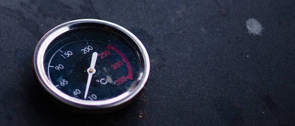 Räucherthermometer getestet: Nahaufnahme einer Skala eines Räucherthermometers auf einem schwarzen Smoker-Deckel.
