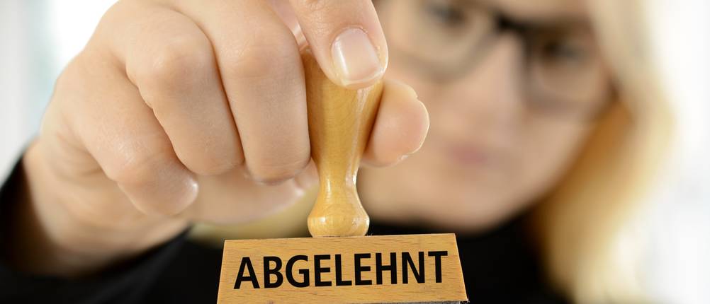 Rahmenkredite im Vergleich: Eine Frau hält einen Stempel in der Hand mit der Aufschrift 