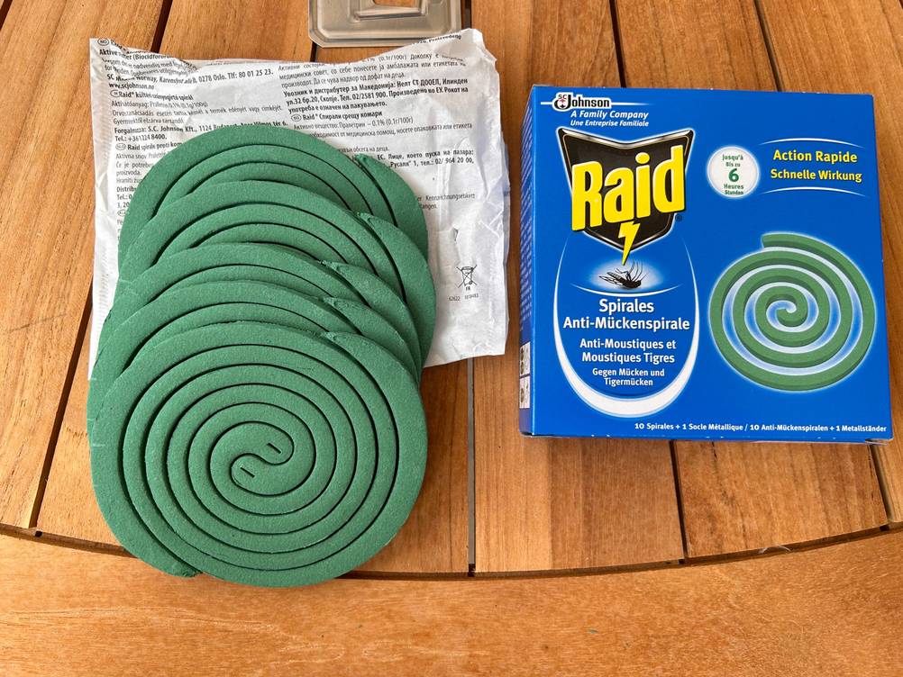 Mückenspirale getestet: Ein Set mit mehreren Spiralen, Halterung und Verpackung liegt auf einer Holzfläche.