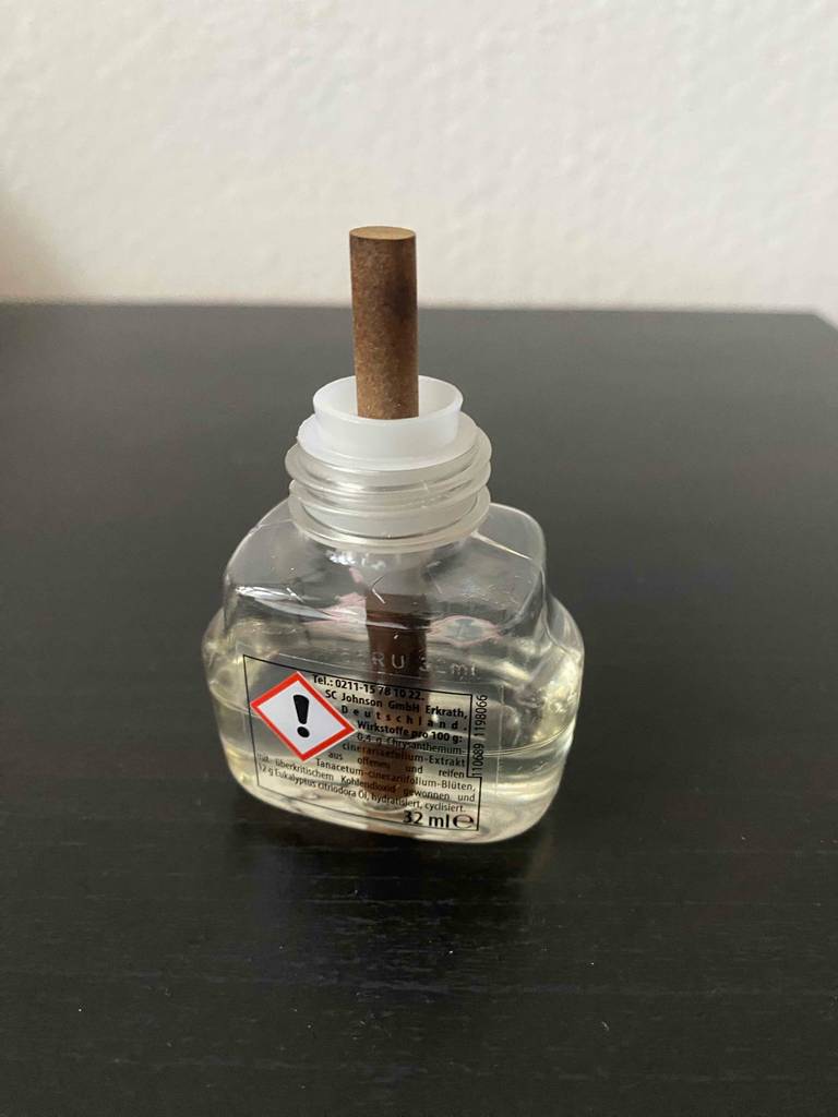 Mückenstecker getestet: Das offene Fläschchen steht mit der Rückseite nach vorn auf einer schwarzen Fläche.