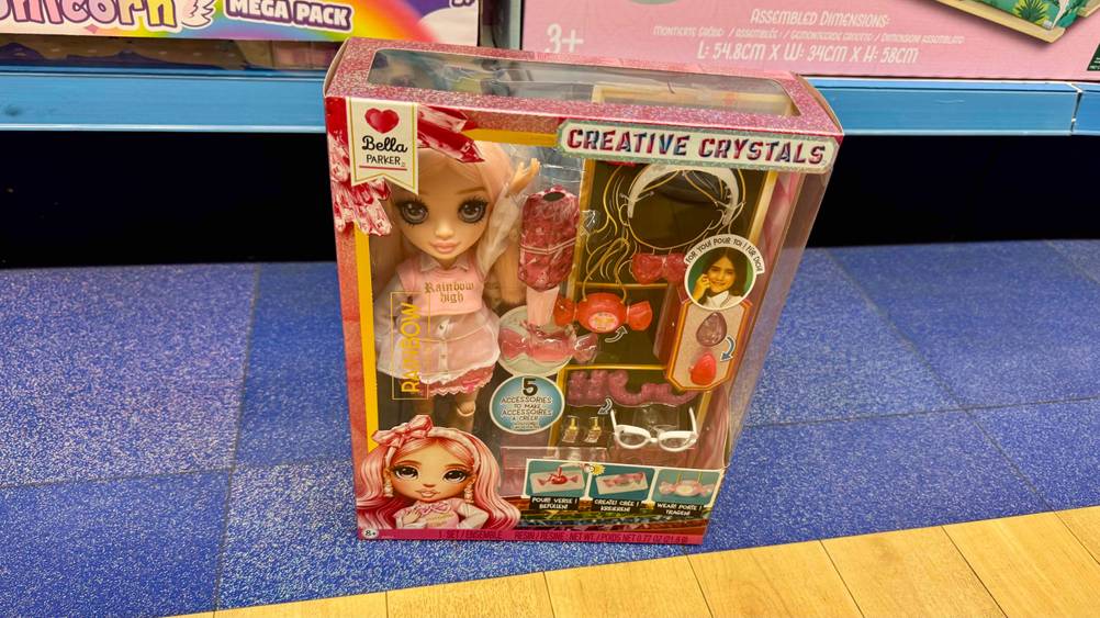 Die getestete Rainbow-High-Puppe mit Accessoires in der transparenenten Verpackung auf dem Boden stehend.