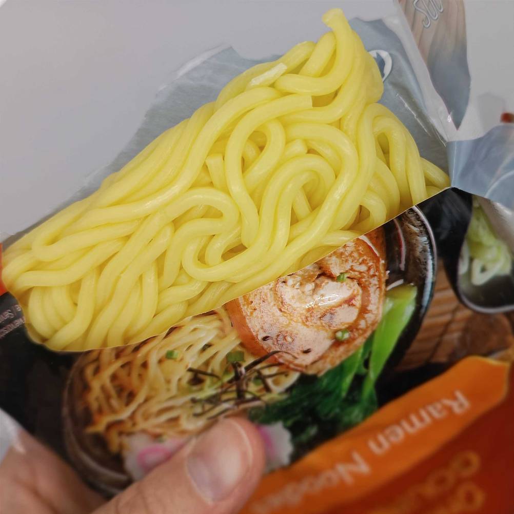 Eine Hand hält eine geöffnete Packung der getesteten Ramen.