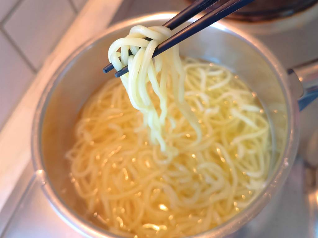 Eine Ramen-Packung im Test: In einem Topf befindet sich erwärmter Ramen.