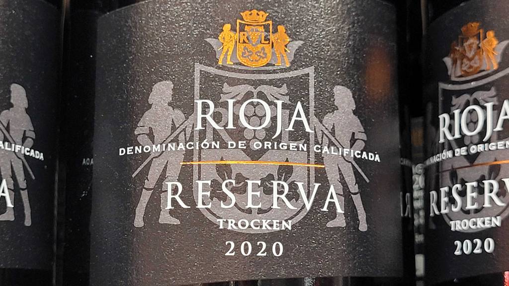 Rioja-Wein im Test: Detailansicht des schwarzen Etiketts auf einer Flasche mit Rotwein.