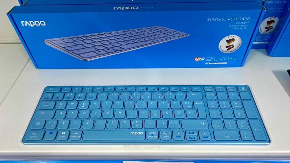 Eine blaue Bluetooth-Tastatur im Test liegt vor ihrer Originalverpackung auf einer hellen Fläche.